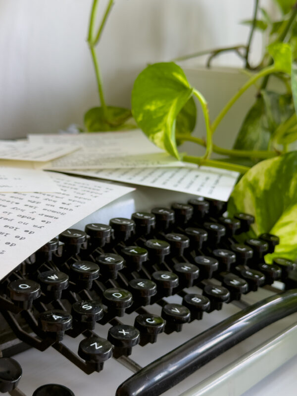 Poema personalizado junto a flores sobre máquina de escribir