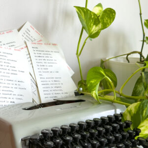Poema personalizado junto a flores sobre máquina de escribir