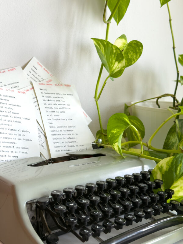 Poema personalizado junto a flores sobre máquina de escribir