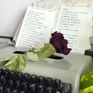 Poema personalizado junto a flores sobre máquina de escribir