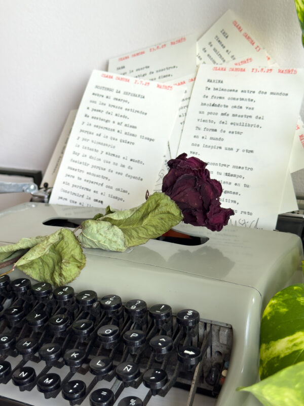 Poema personalizado junto a flores sobre máquina de escribir